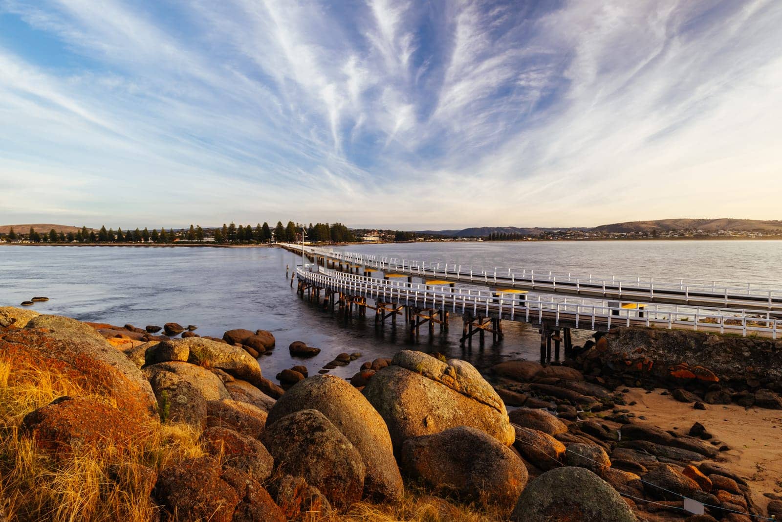 A view of the famous causeway leading to Granite Island Recreation Park at sunrise in Victor Harbor on a sunny autumn day in South Australia, Australia