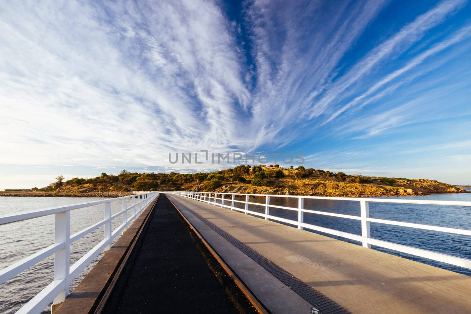 A view of the famous causeway leading to Granite Island Recreation Park at sunrise in Victor Harbor on a sunny autumn day in South Australia, Australia