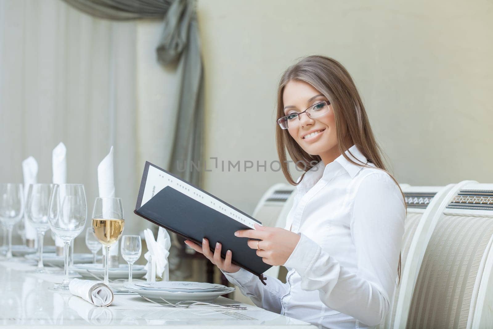 Smiling charming woman posing with menu in restaurant, close-up