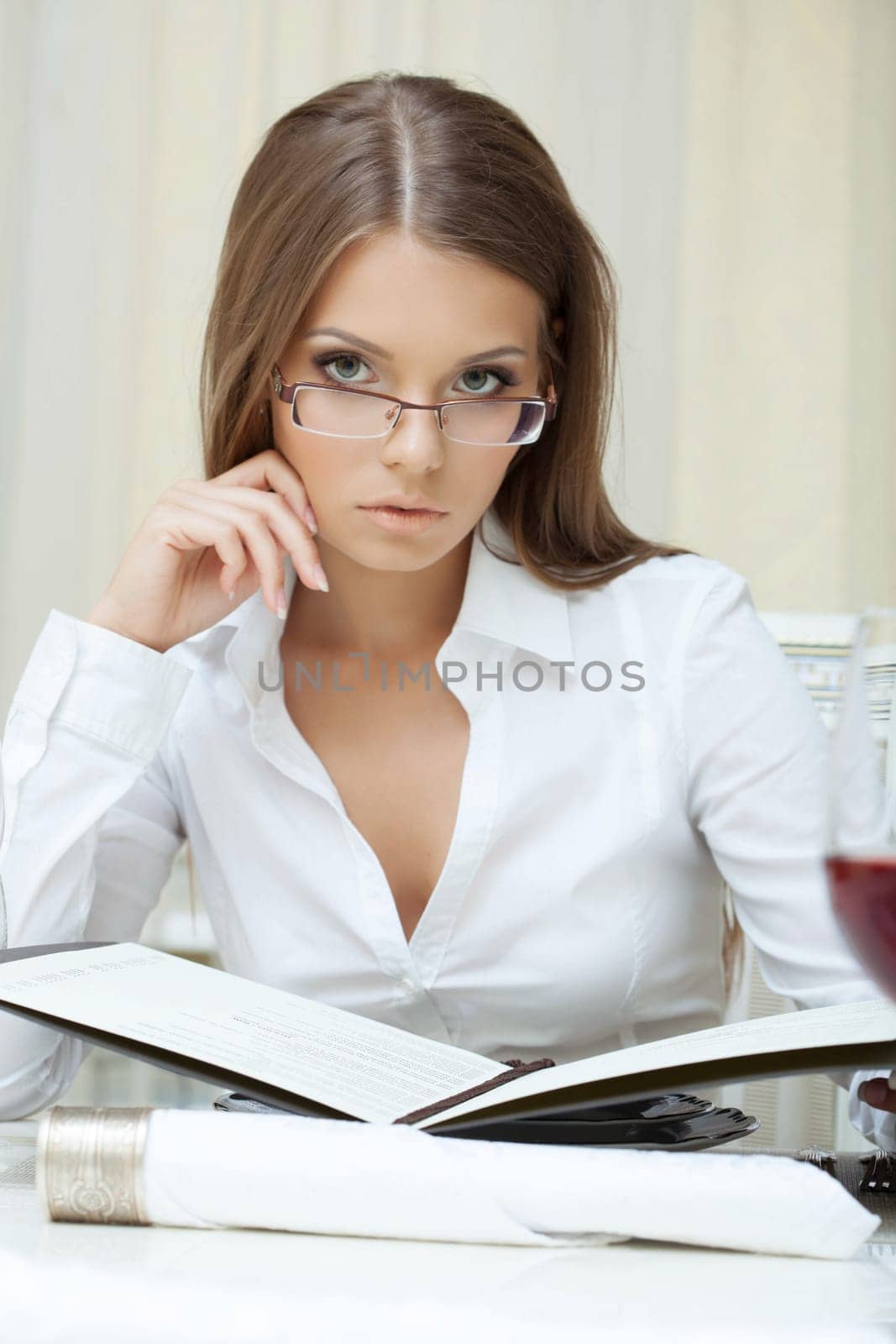 Portrait of pensive business woman in glasses posing with folder