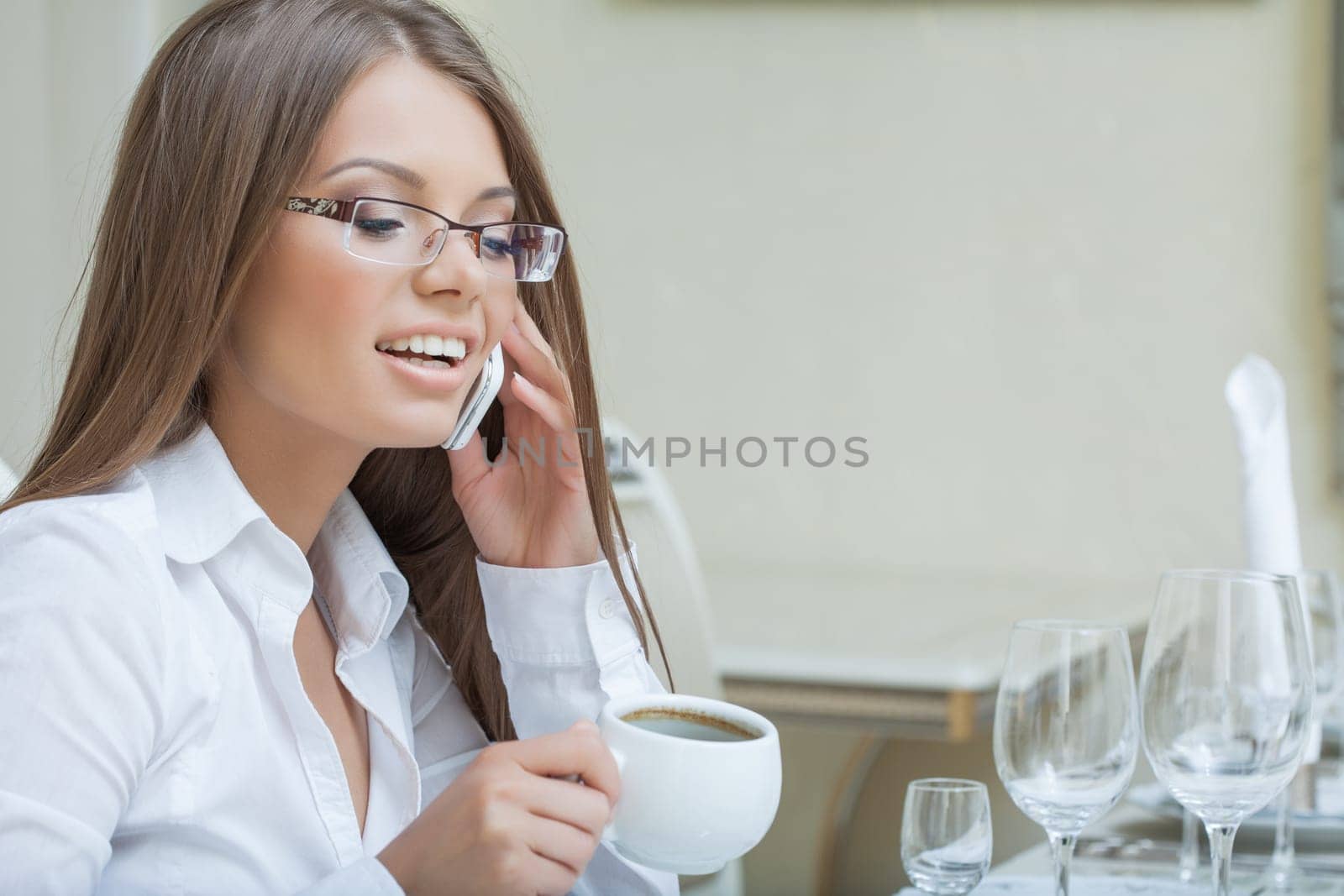 Portrait of smiling young woman talking on cell, close-up