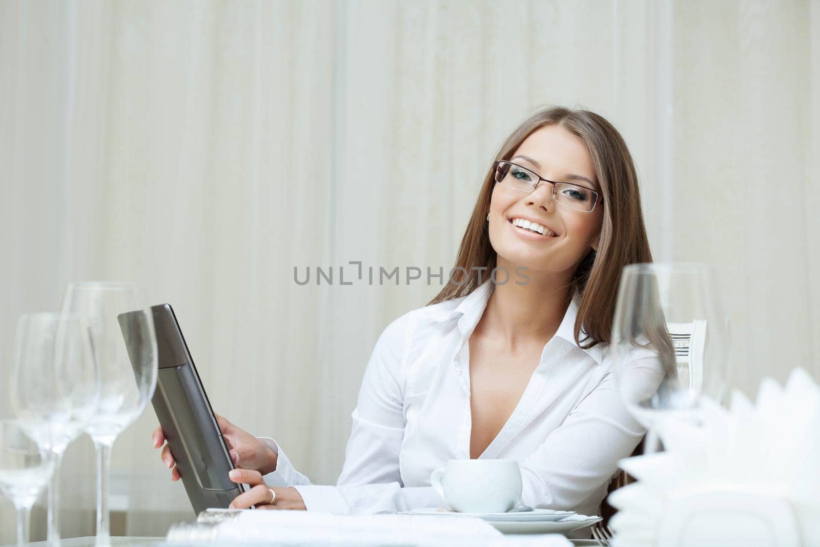 Cute smiling woman in glasses works on notebook, close-up