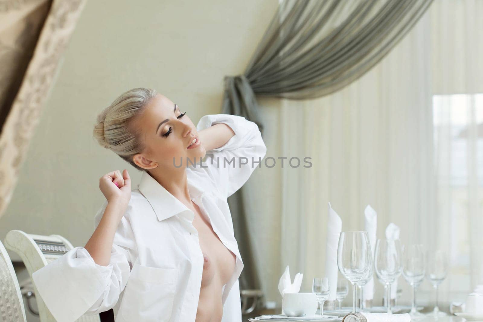 Portrait of beautiful topless woman stretching in restaurant
