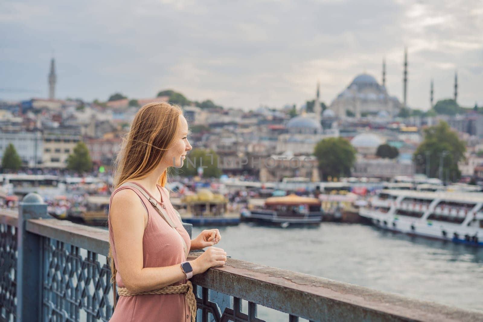 Young tourist woman on Galata bridge, Golden Horn bay, Istanbul. Panorama cityscape of famous tourist destination Bosphorus strait channel. Travel landscape Bosporus, Turkey, Europe and Asia.