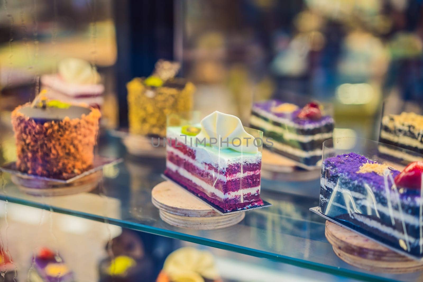 Different types of cakes in pastry shop glass display by galitskaya