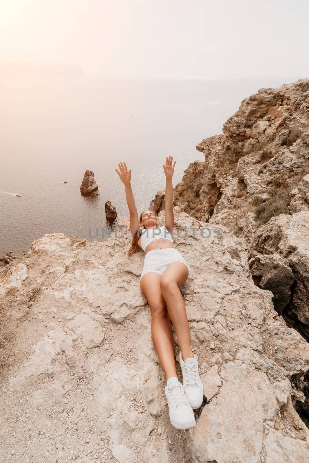 Woman travel sea. Young Happy woman posing on a beach over the sea on background of volcanic rocks, like in Iceland, sharing travel adventure journey by panophotograph