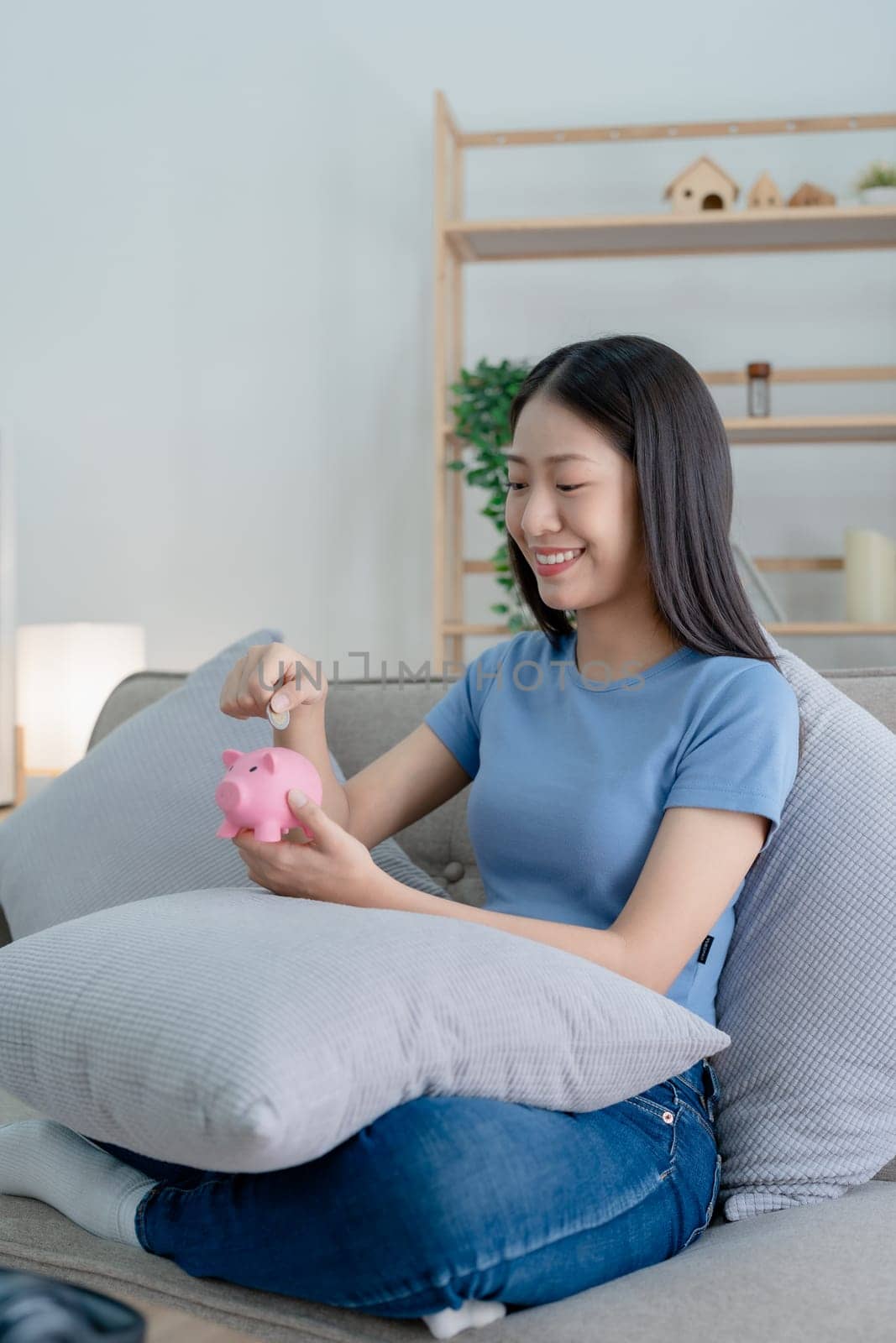 Asian young woman holding a piggy bank and coin, Savings concepts