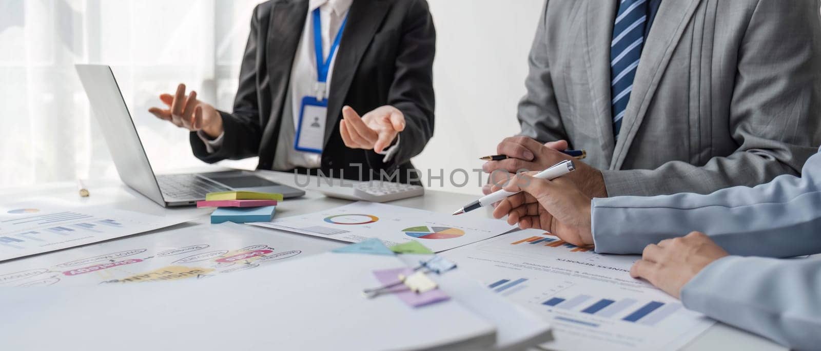 Business People Meeting using laptop computer,calculator,notebook,stock market chart paper for analysis Plans to improve quality next month. Conference Discussion Corporate Concept