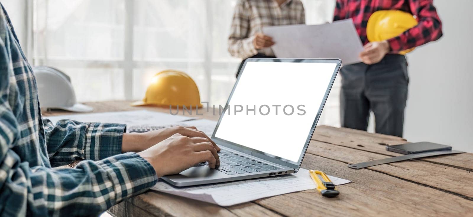 Civil engineer teams meeting working together wear worker helmets hardhat on construction site in modern city. Foreman industry project manager engineer teamwork. Asian industry professional team.