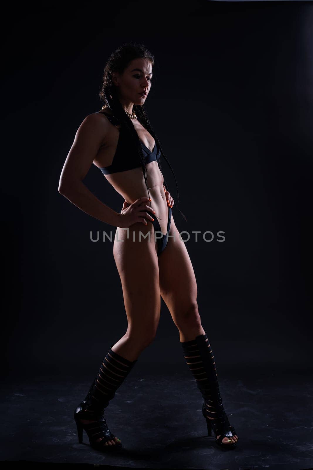 Perfect woman body on a black background studio, sport muscles belly