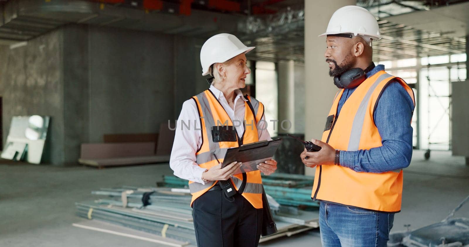 Construction, inspection and clipboard, black man and woman discussion, construction site with scaffolding and building renovation checklist. Contractor with inspector, engineering and communication. by YuriArcurs