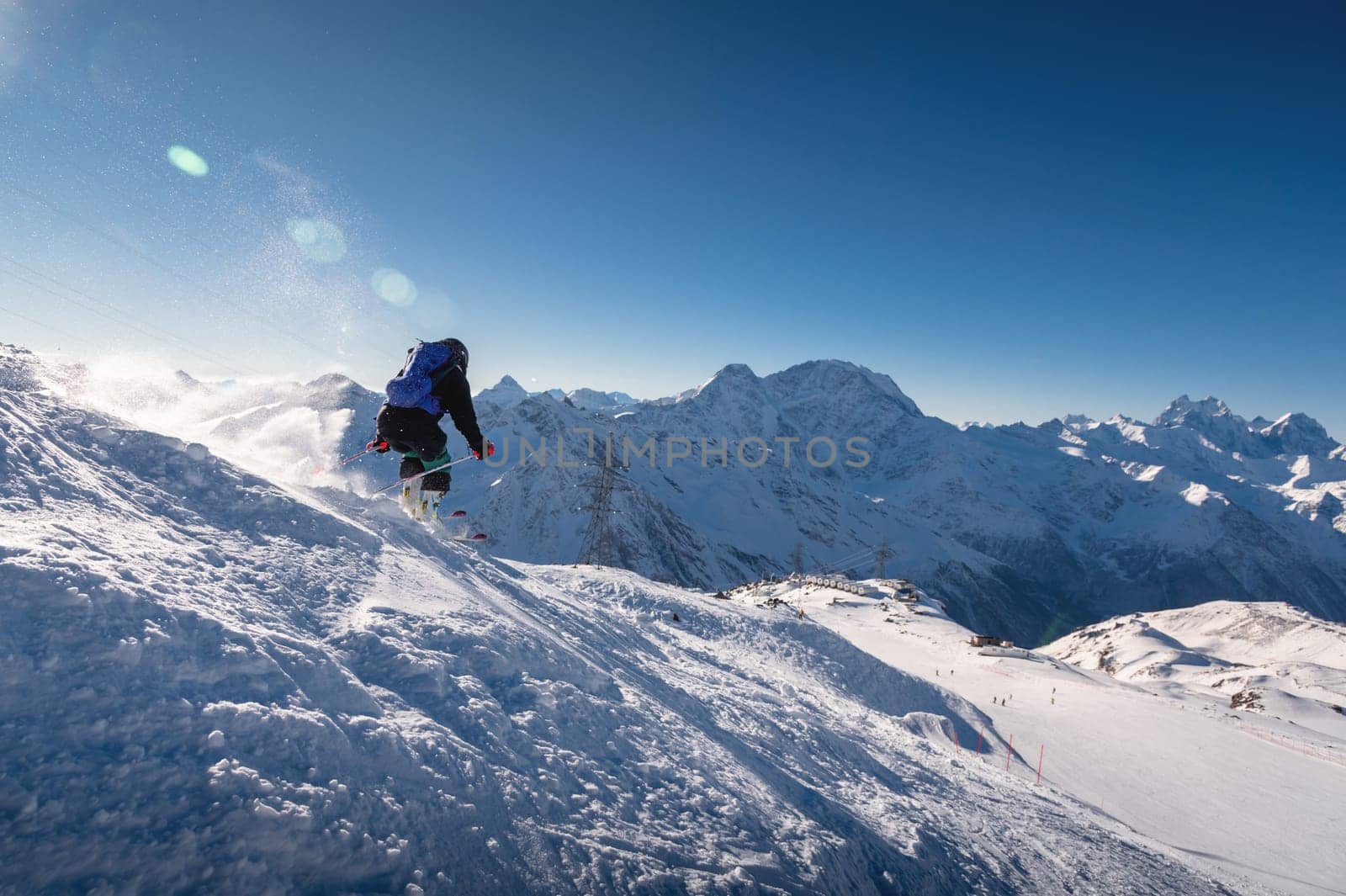 good skiing in snowy mountains. a nice winter day, an incredible ski drive from which a female skier jumps against the backdrop of a snowy sunny day by yanik88