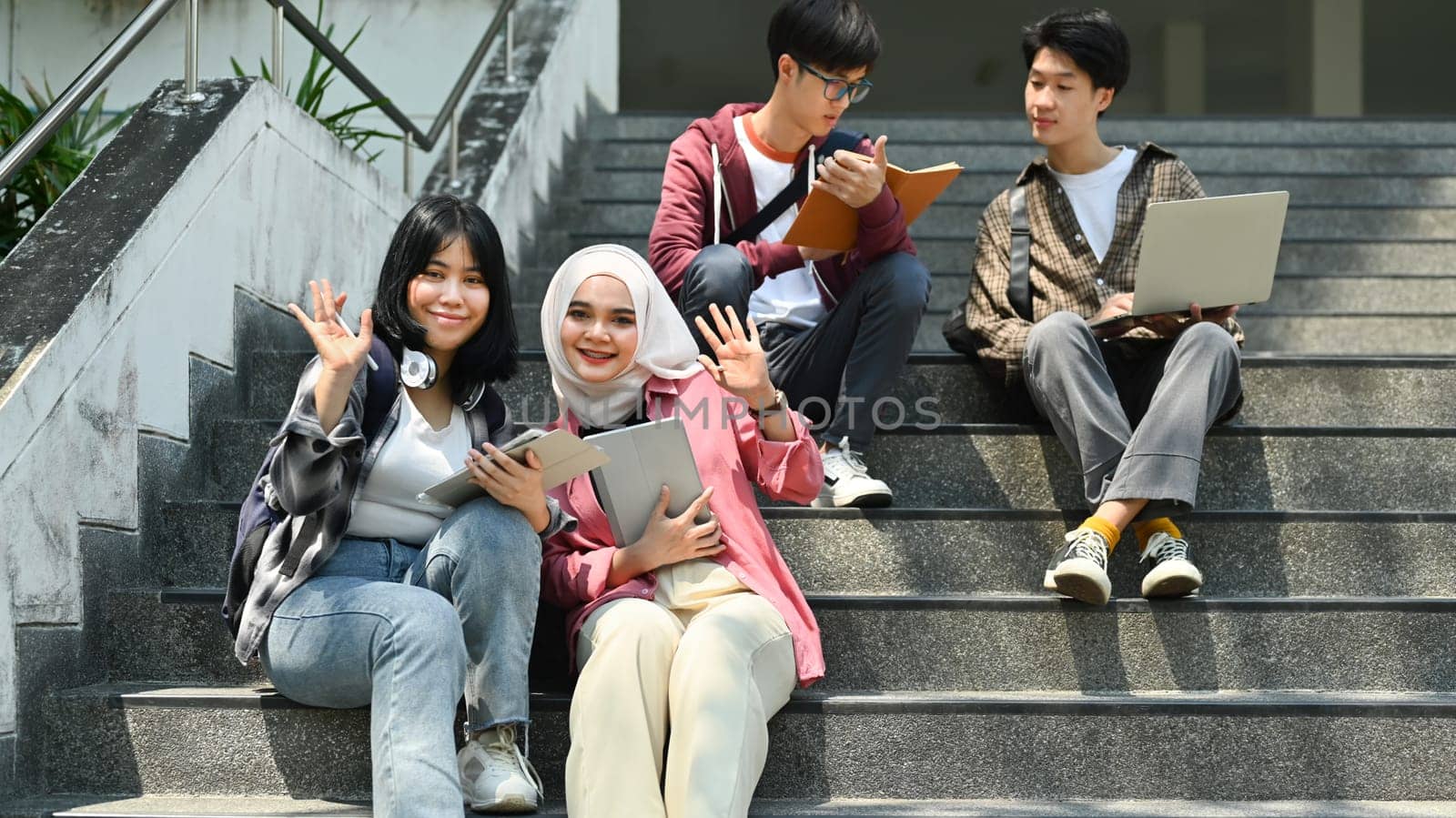 Group of cheerful college students spending time together on campus. Friendship and lifestyle concepts.
