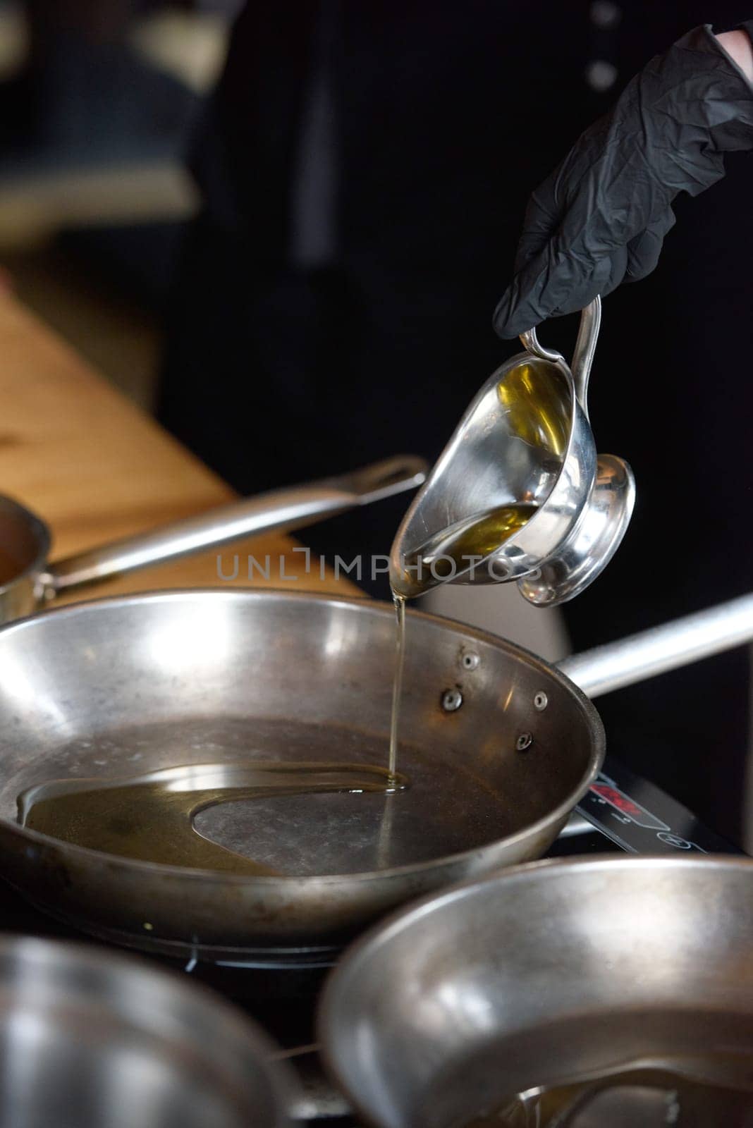 Pouring vegetable oil into frying stainless steel pan