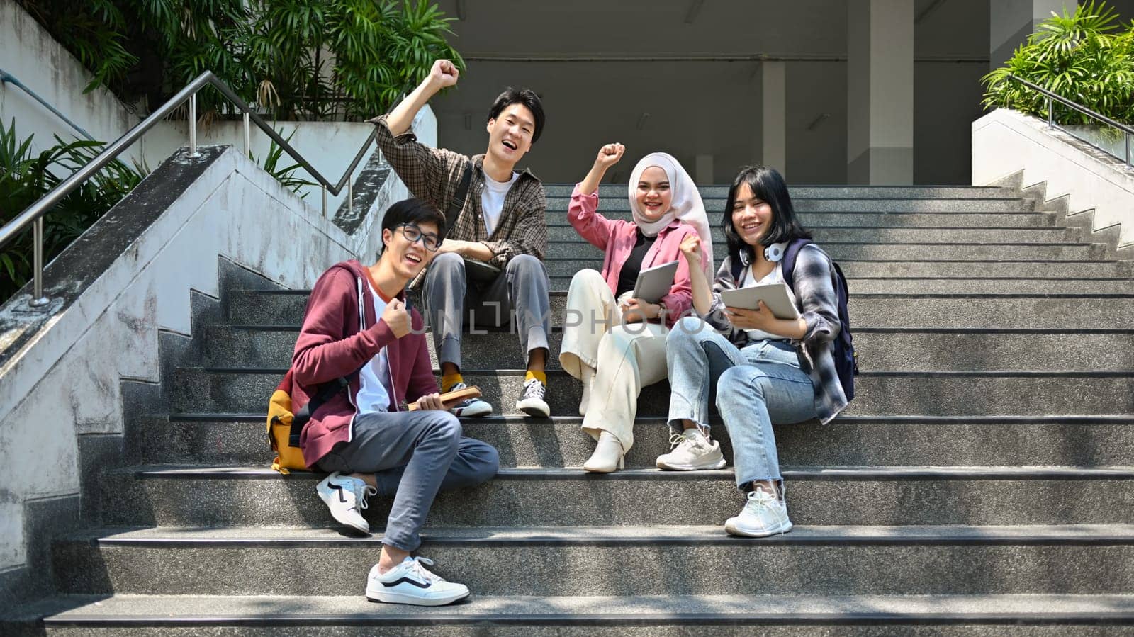 Group of young friends laughing and celebrating together. Friendship, community, youth, university concept.