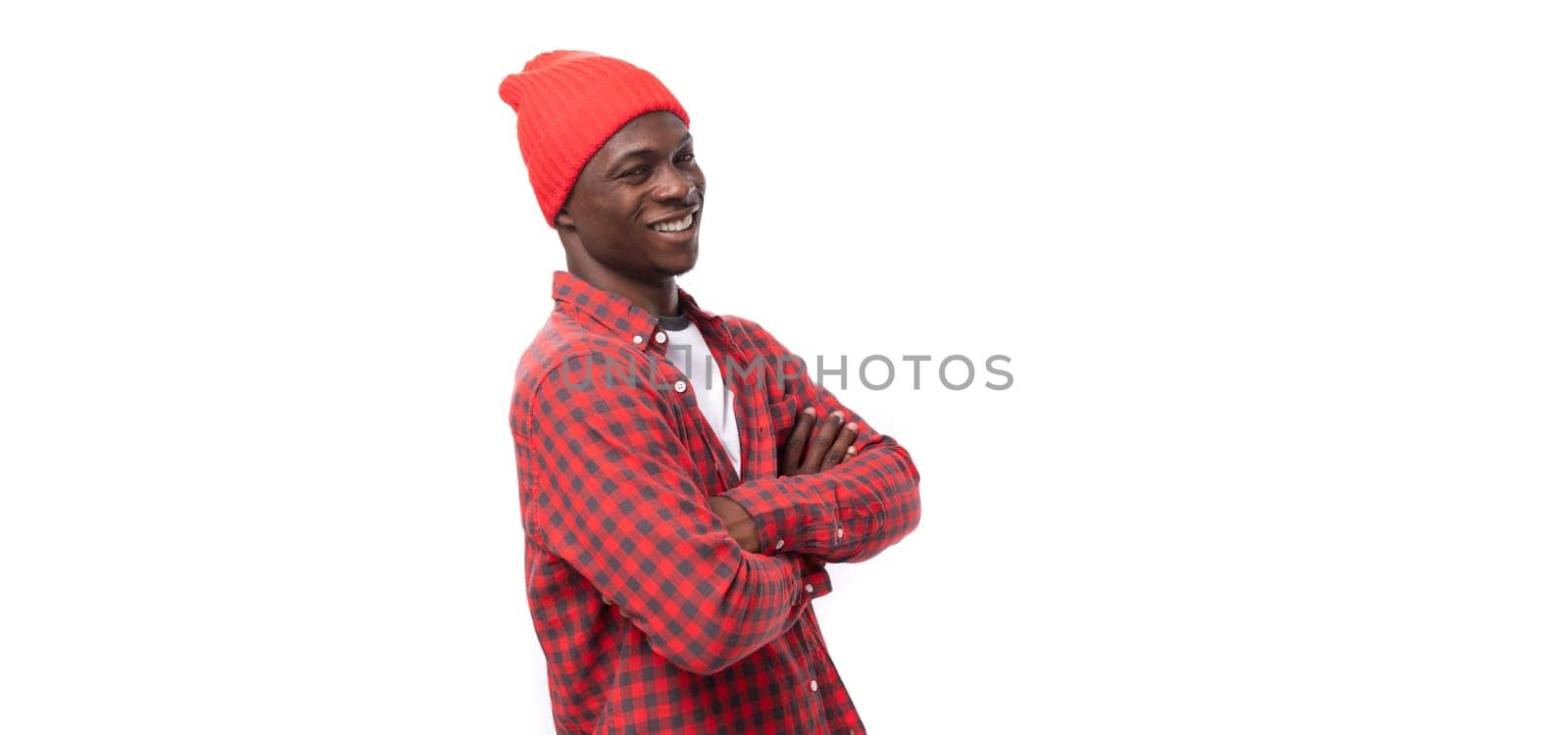 handsome embarrassed dark-skinned man in a casual plaid shirt of model appearance on a white background with copy space.