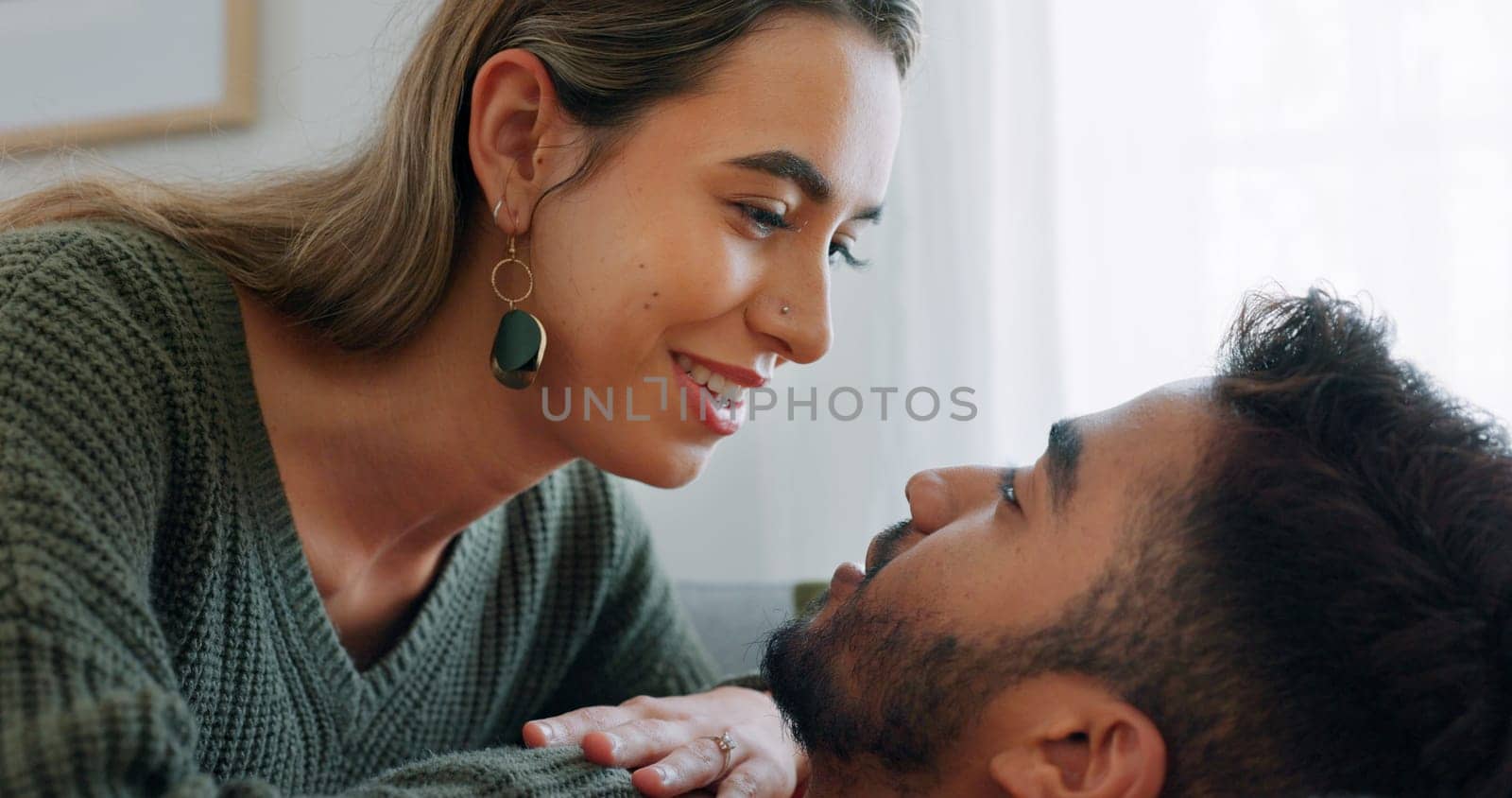 Interracial, couple, love and kiss being happy, bonding and embrace for communication, talking together and at home. Romantic, man and woman with smile, intimate and being loving for romance or hug.
