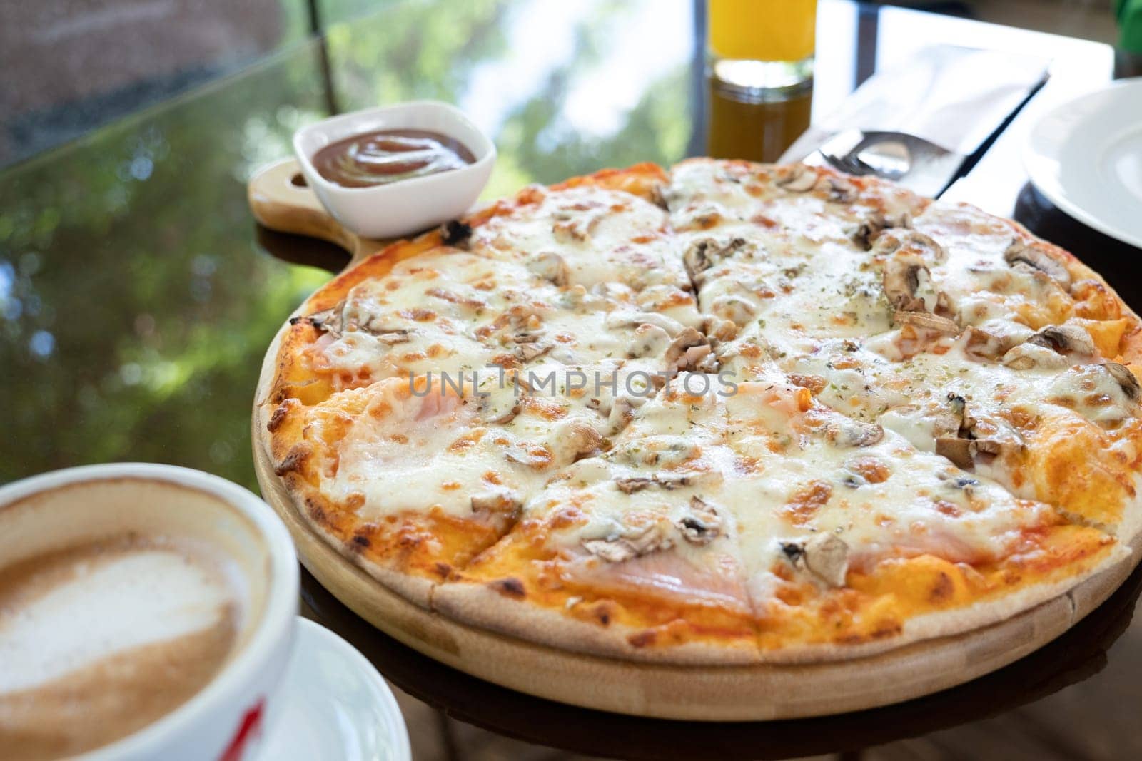 citalian chicken pizza with mozarella cheese on glass table in street cafe, coffee and drinks around