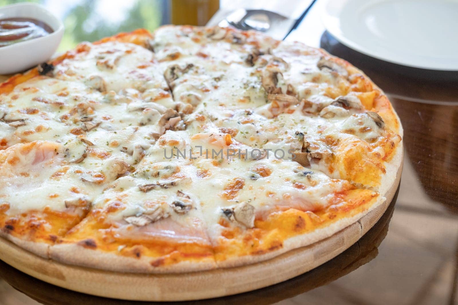 italian chicken pizza with mozarella cheese on glass table in street cafe by Desperada