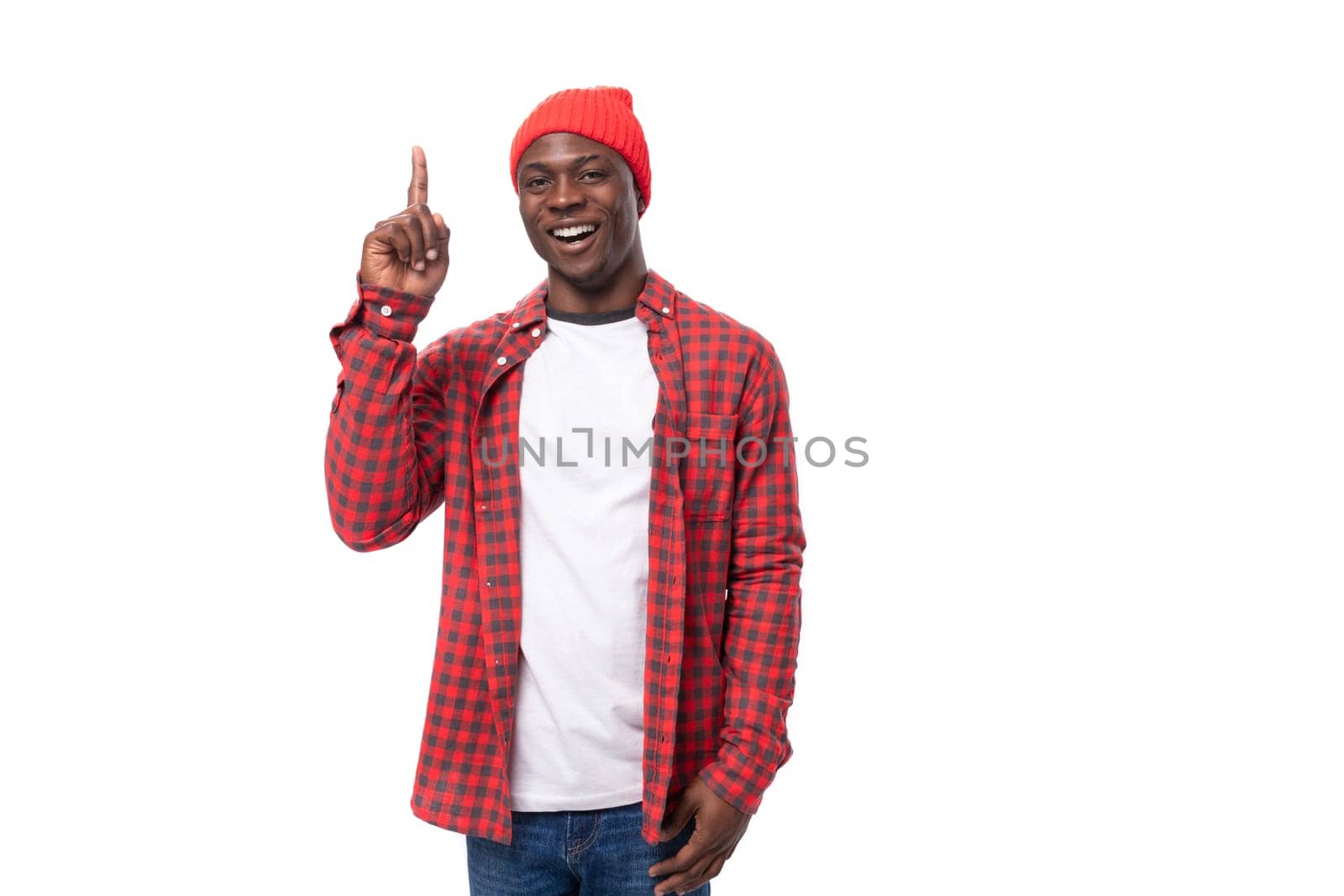 smart cute 30s black american man dressed in red shirt and cap communicates idea on white studio background with copy space.
