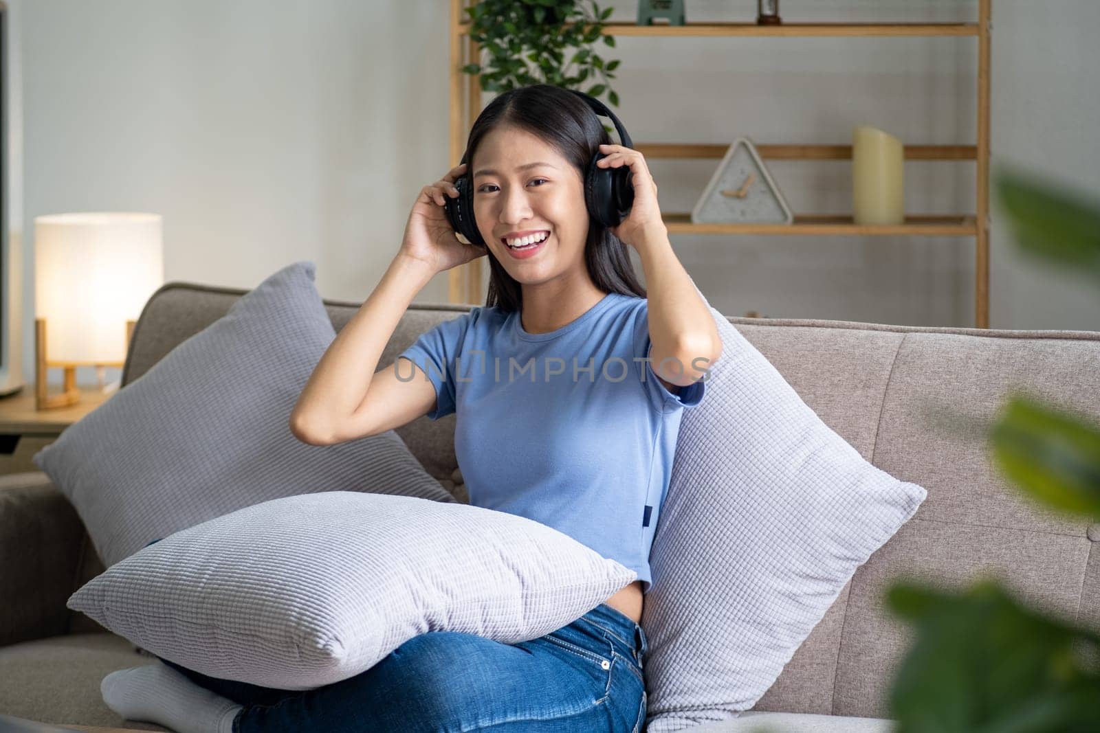 Young happy relaxing rest chilling woman sit on sofa listen to music song, happy life. High quality photo