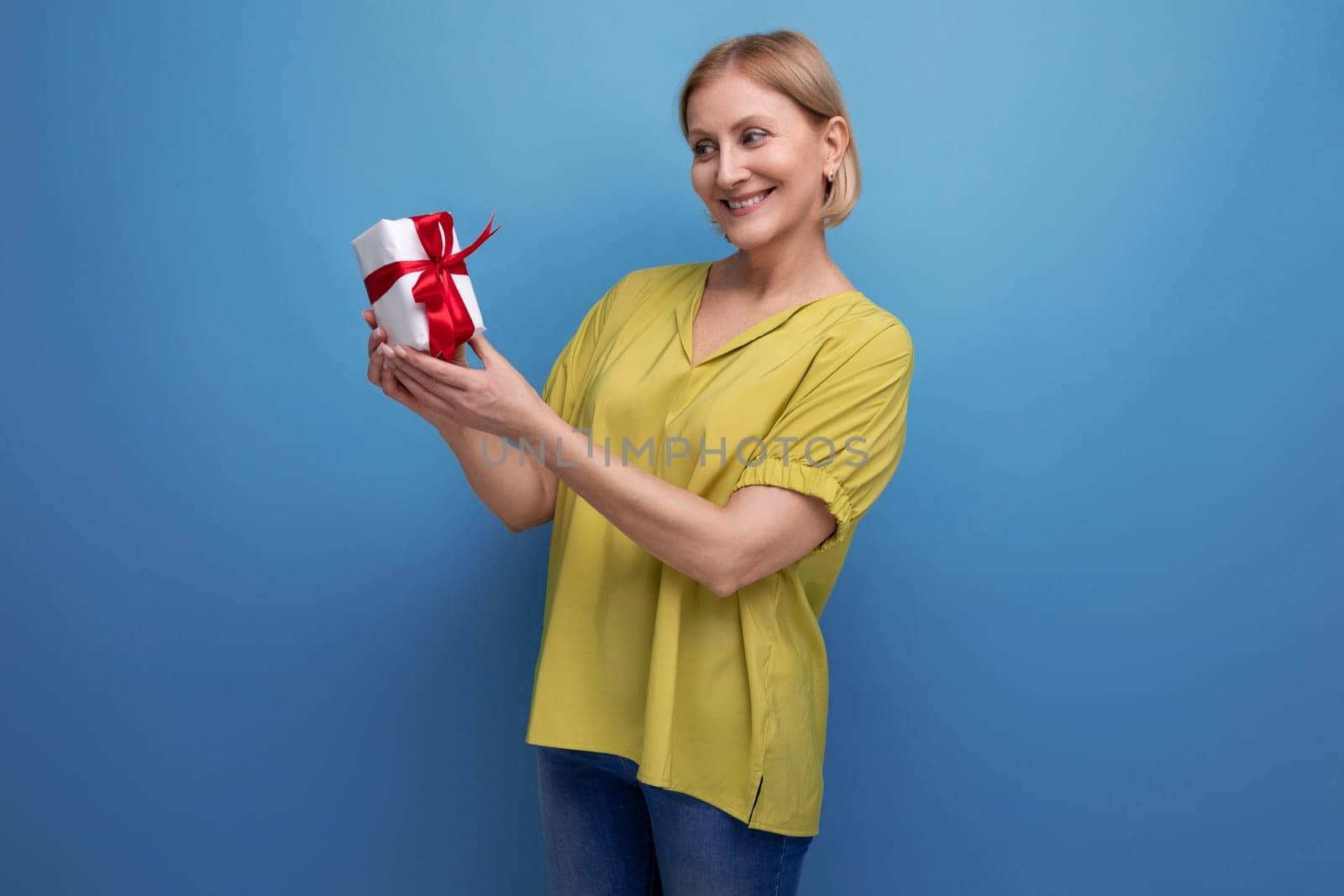 joyful blond middle-aged woman received her birthday present by TRMK