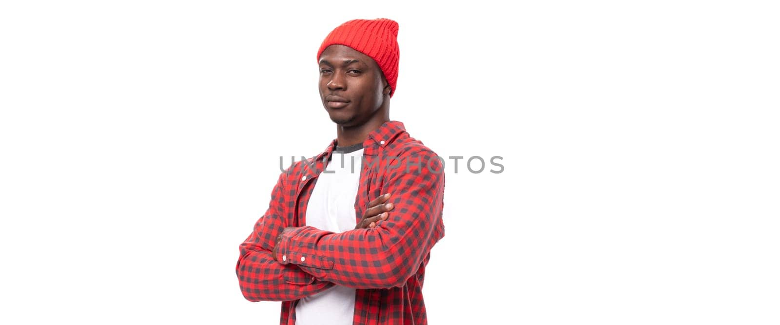 successful handsome 30s black american man dressed in red shirt and cap on white studio background with copy space by TRMK