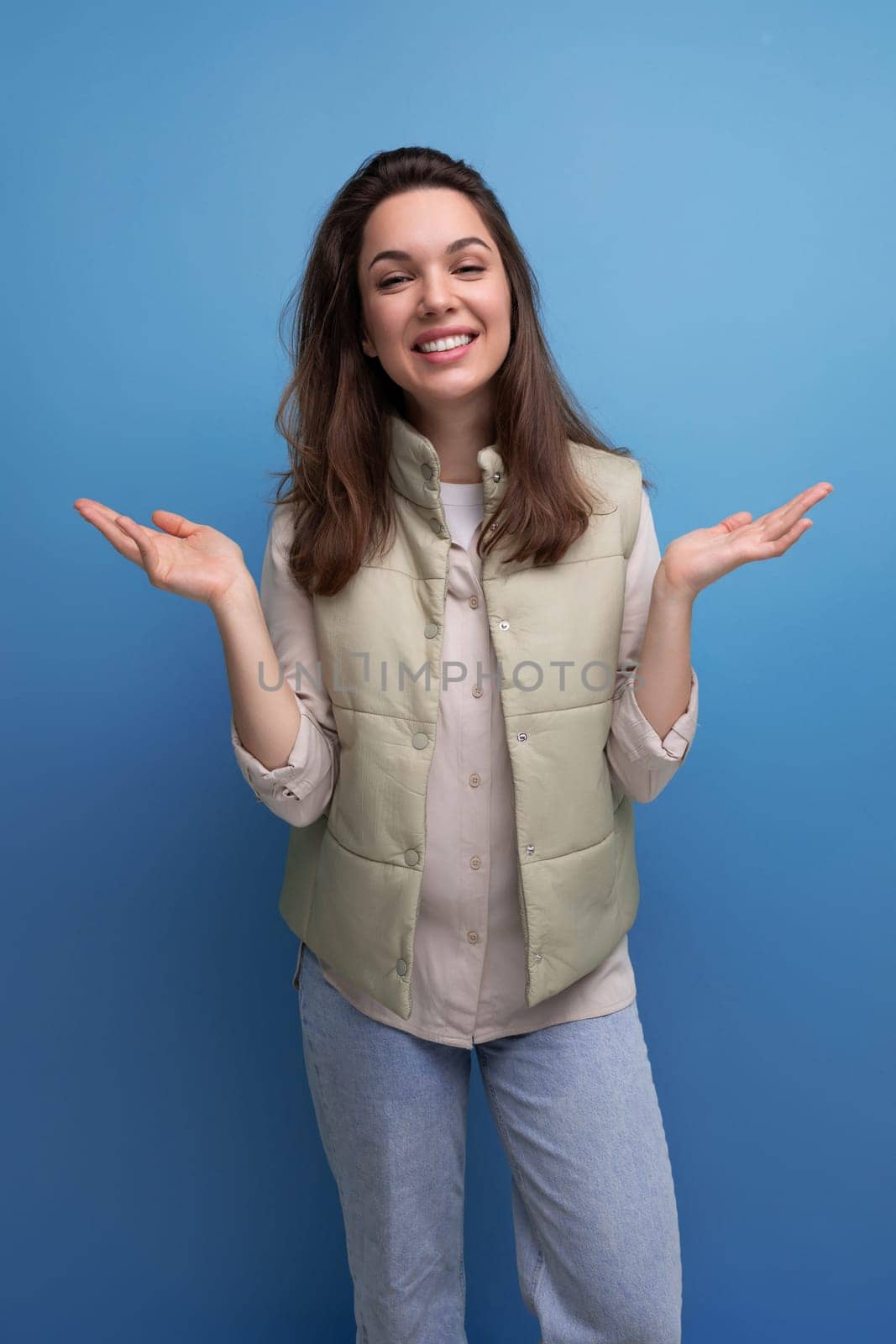 charming positive brunette young lady in casual style on studio background.