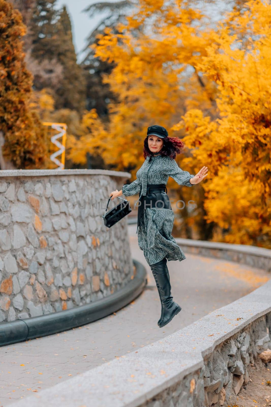 A woman walks outdoors in autumn, enjoys the autumn weather. by Matiunina