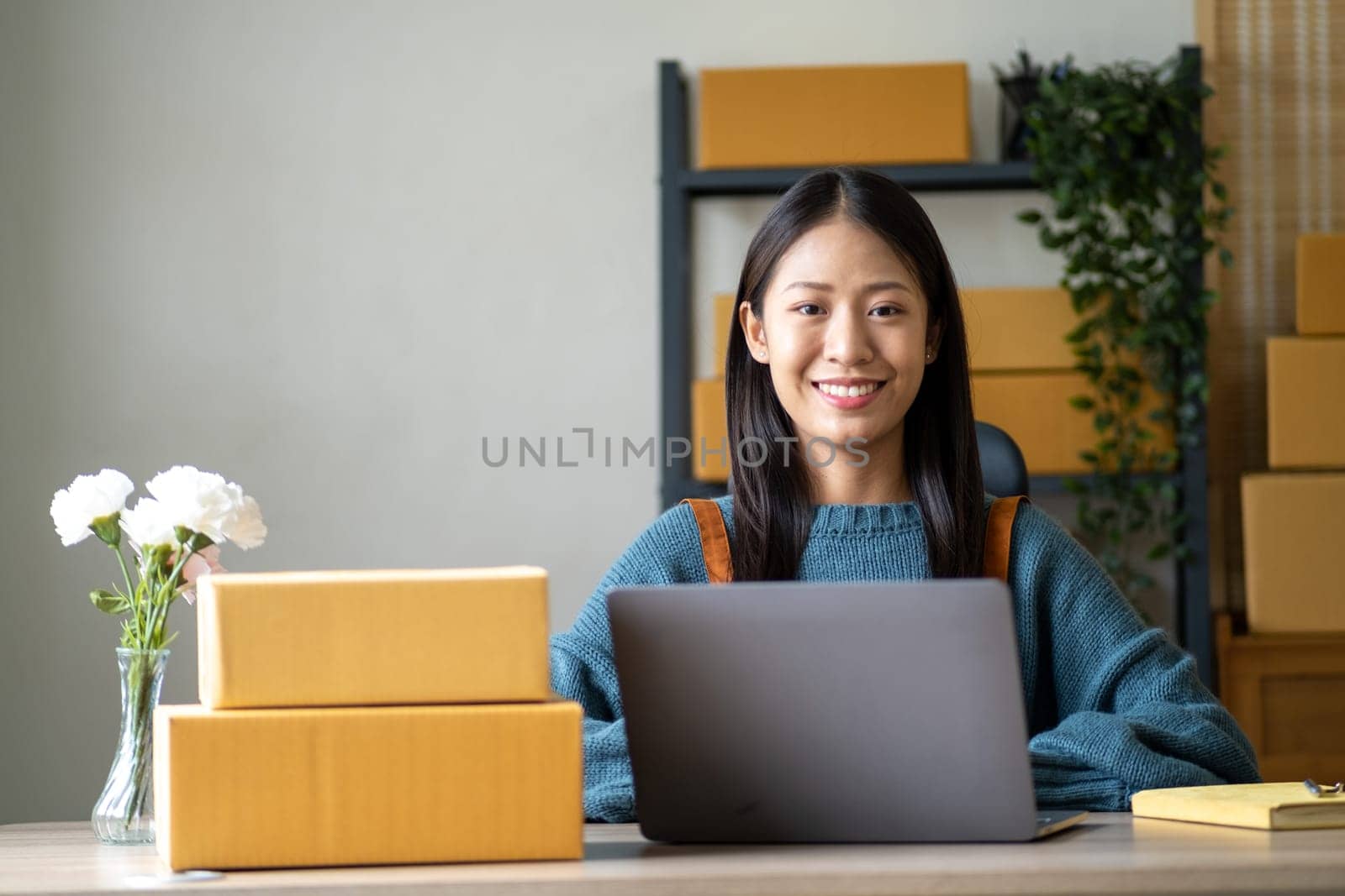 Young happy Asian woman looking at laptop screen, celebrate for sell, smile young entrepreneur happy for sale successful . High quality photo