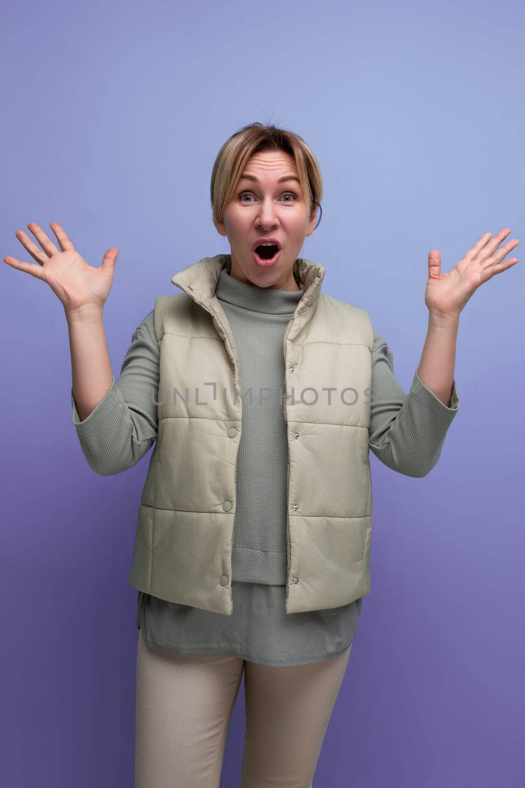 blond surprised joyful young woman shows joy with hands.