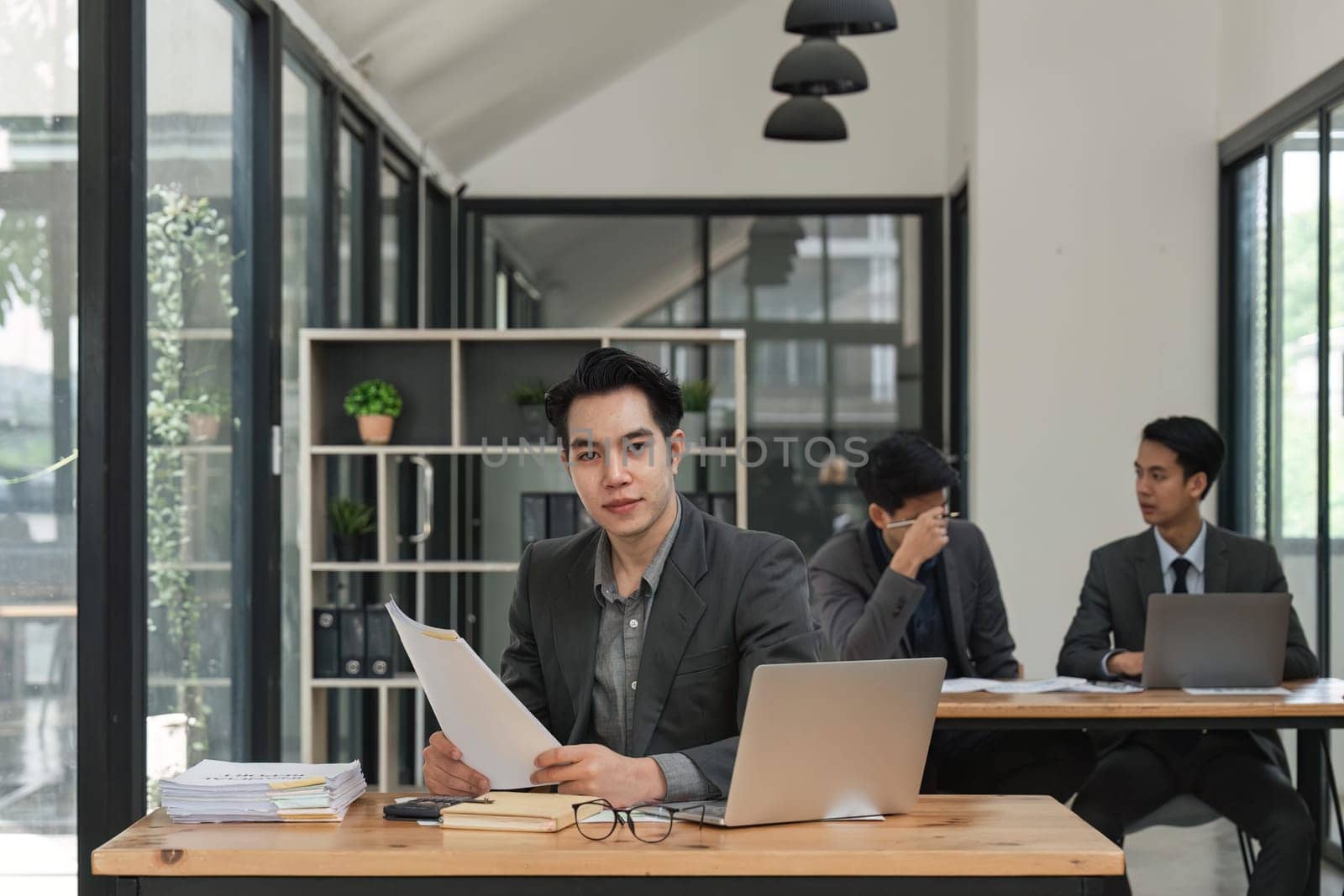 Smiling male business sitting in office and working on laptop.