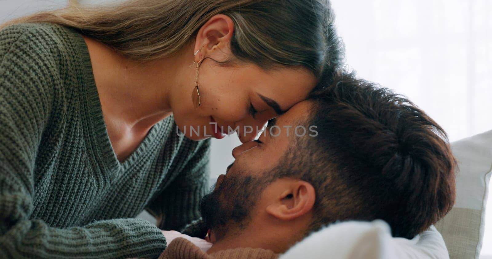 Interracial, couple, love and kiss being happy, bonding and embrace for communication, talking together and at home. Romantic, man and woman with smile, intimate and being loving for romance or hug.