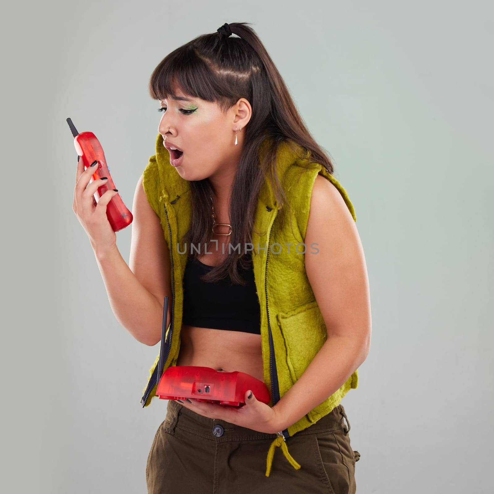 Wow, anger and woman on a telephone call isolated on a grey studio background. Fashion, communication and surprised girl holding a landline phone for conversation, talking and bad news on a backdrop.