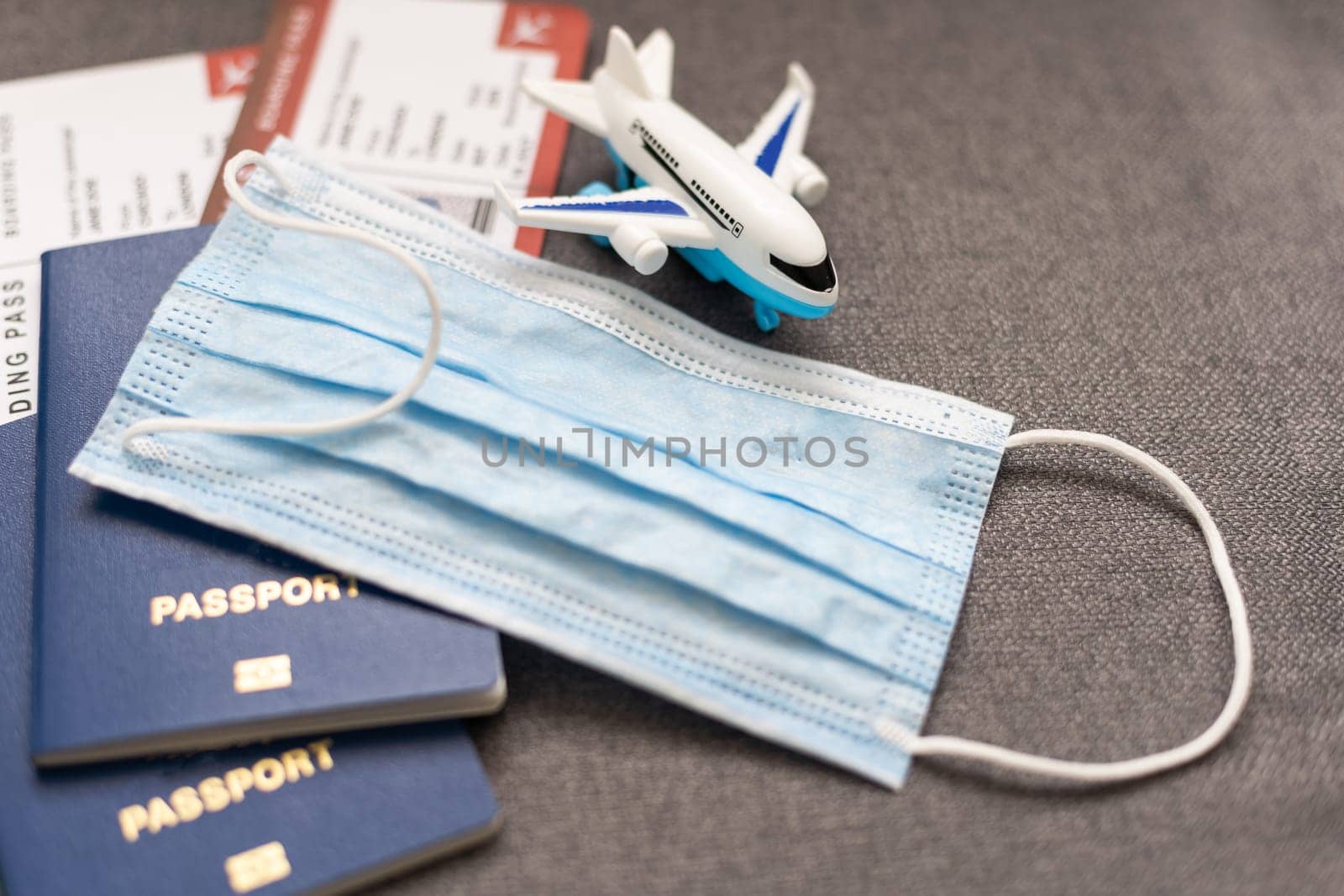 travel during the covid-19 pandemic. airplane model with face mask and travel documents. by Andelov13