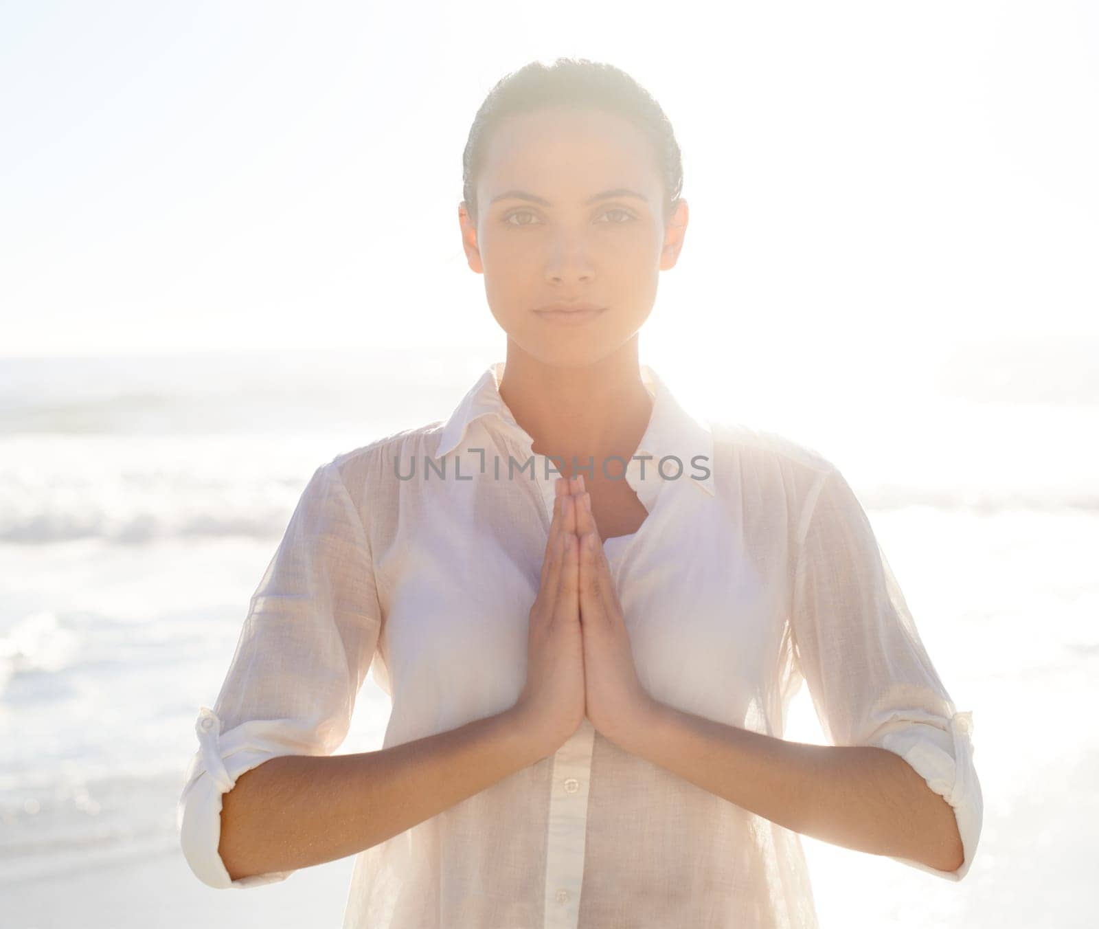 Nature helps me find peace. A beautiful young woman meditating outside. by YuriArcurs