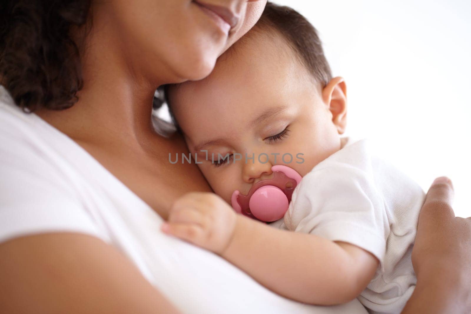 The safety of a mothers arms...Closeup of a baby girl sleeping in her mothers arms. by YuriArcurs