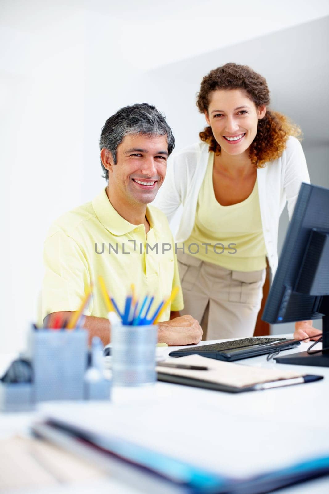 Business people smiling at work. Portrait of two business people smiling at work. by YuriArcurs