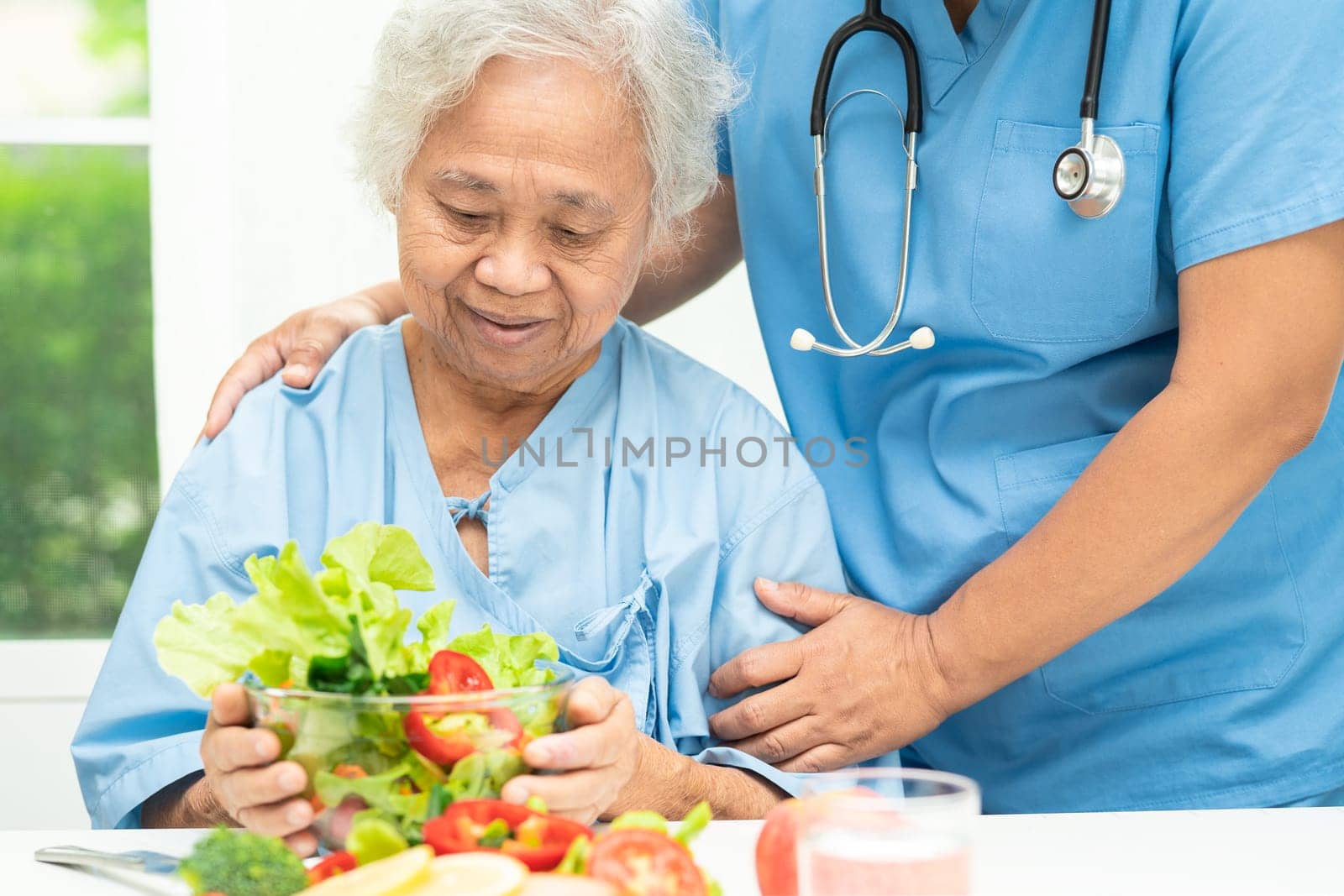 Asian elderly woman patient eating salmon steak breakfast with vegetable healthy food in hospital. by pamai