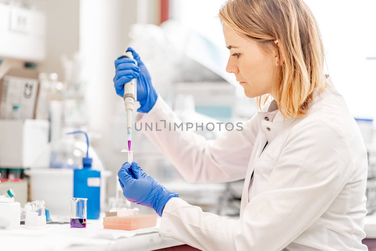 young attractive female scientist examines chemical samples of substances and drugs in a research laboratory. High quality photo