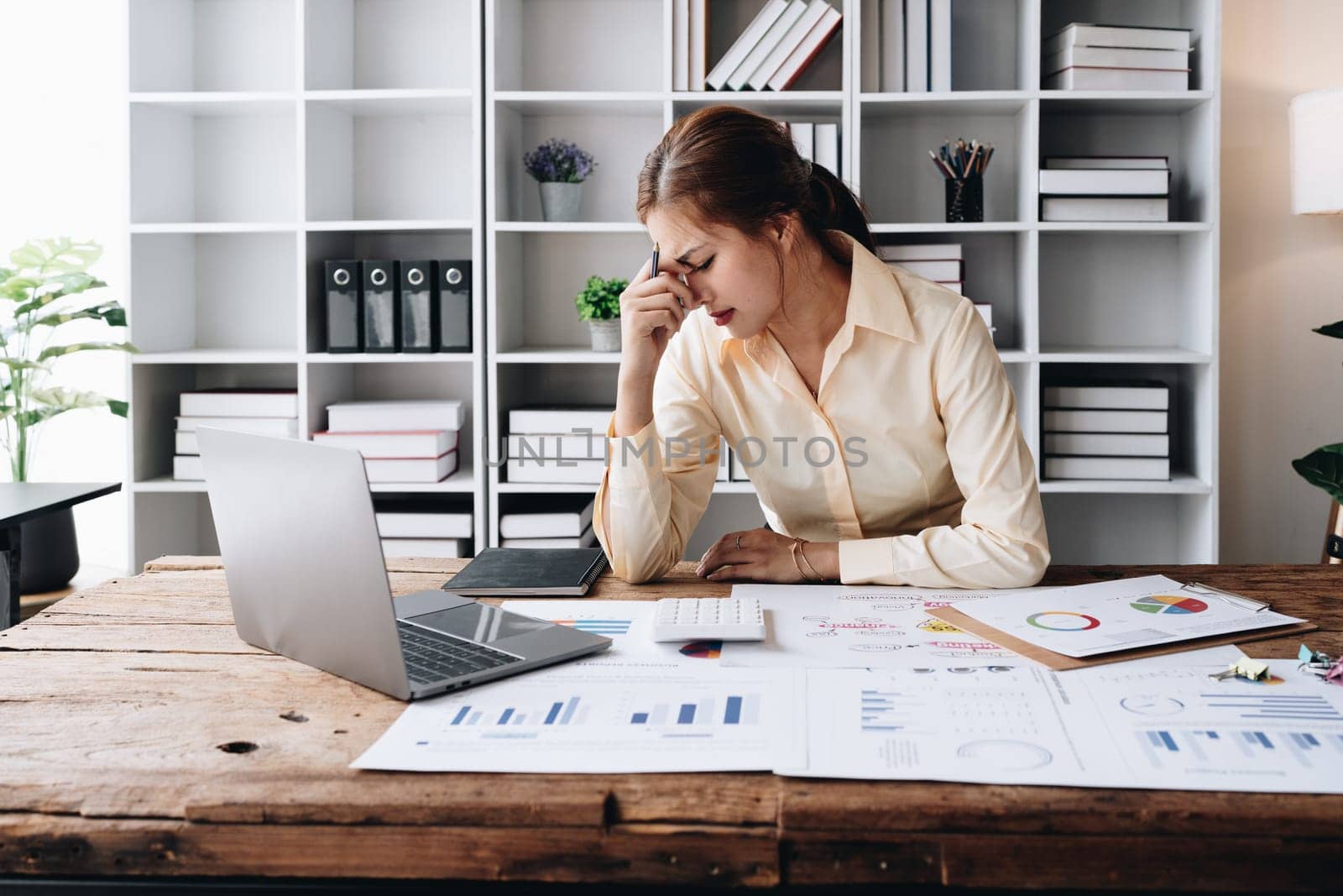 Portrait of business owner, woman using computer and financial statements Anxious expression on expanding the market to increase the ability to invest in business.