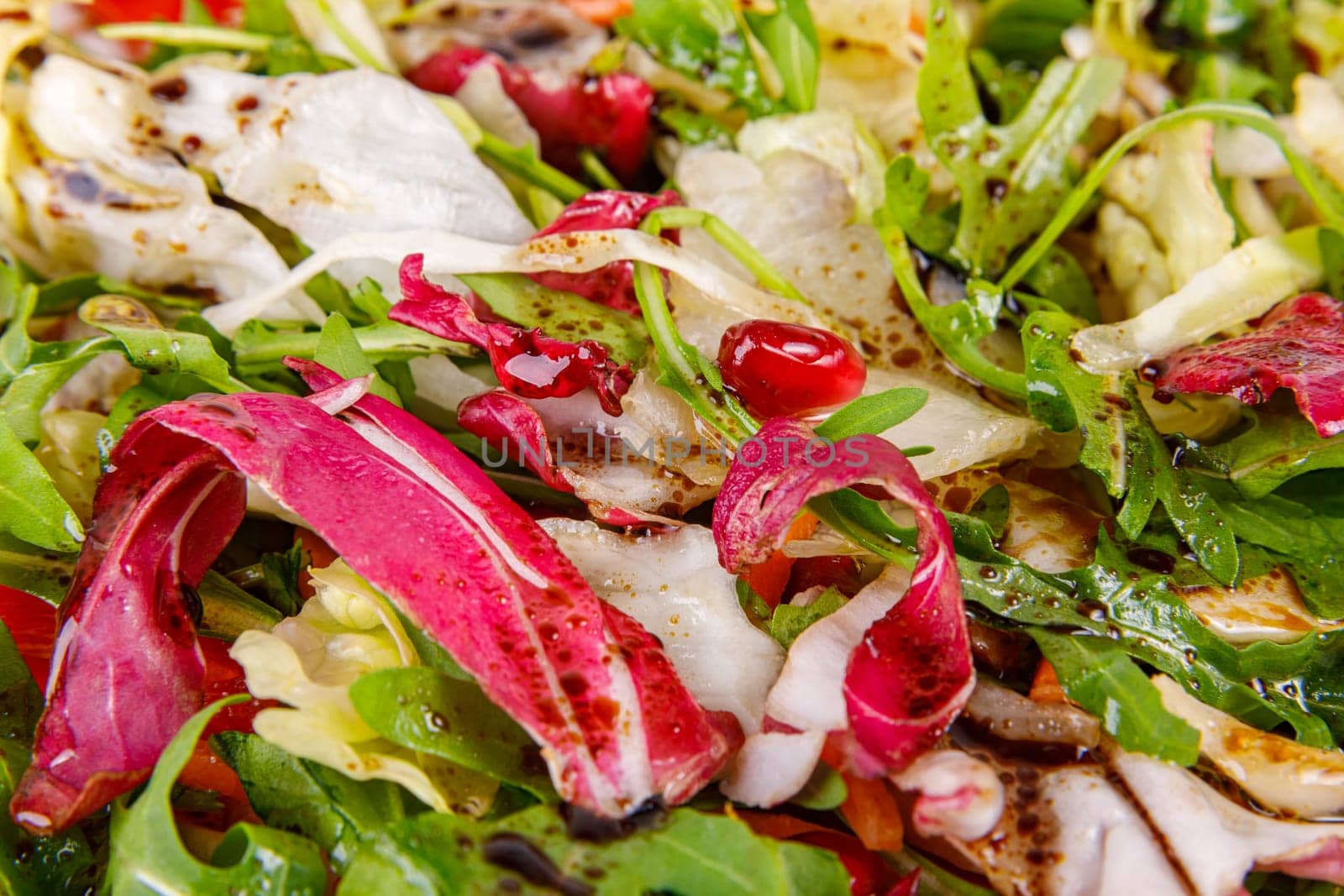 Fresh salad of cabbage, herbs, peppers, carrots and pomegranate seeds, close-up. High quality photo