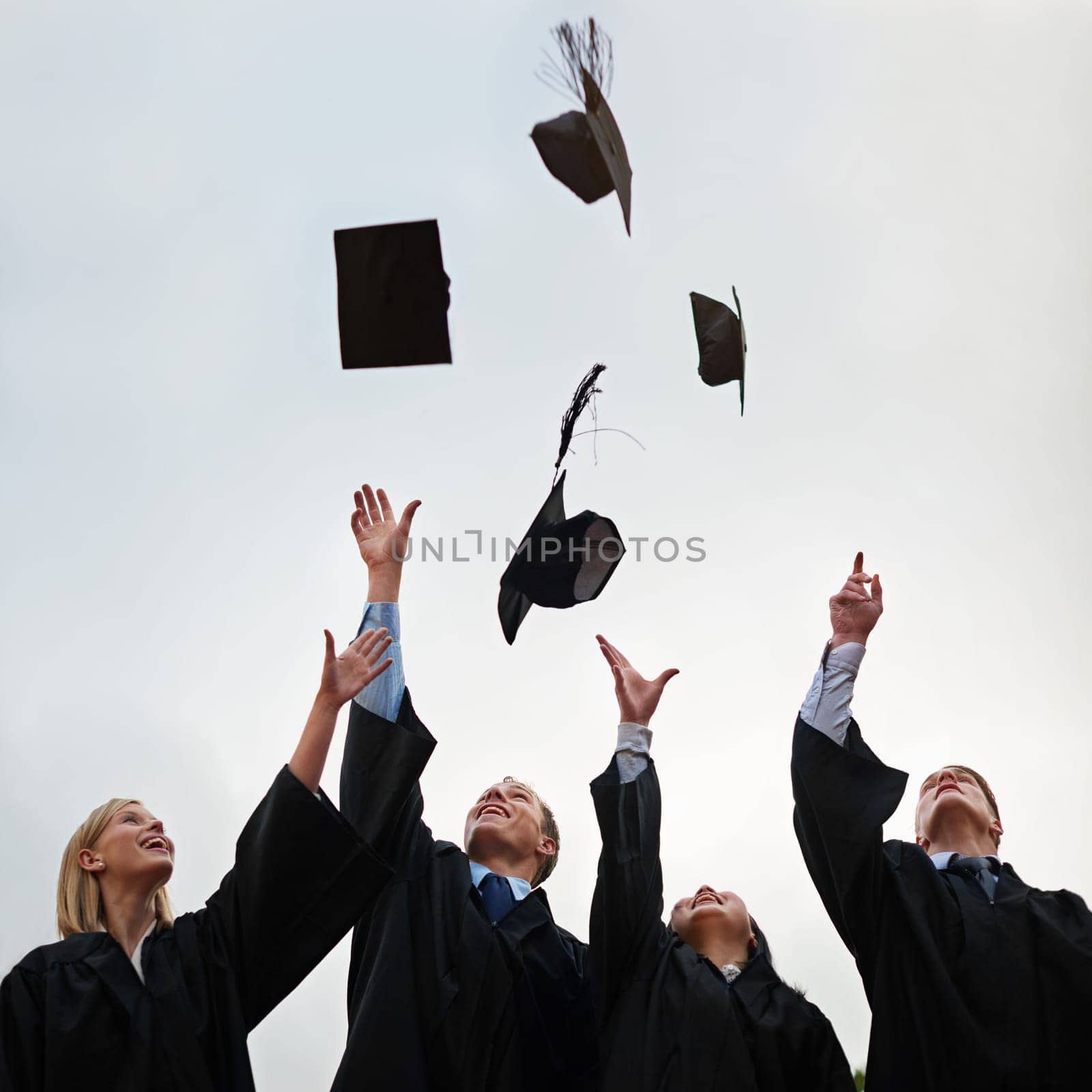 We did it. A group of students throwing their caps into the air after graduation