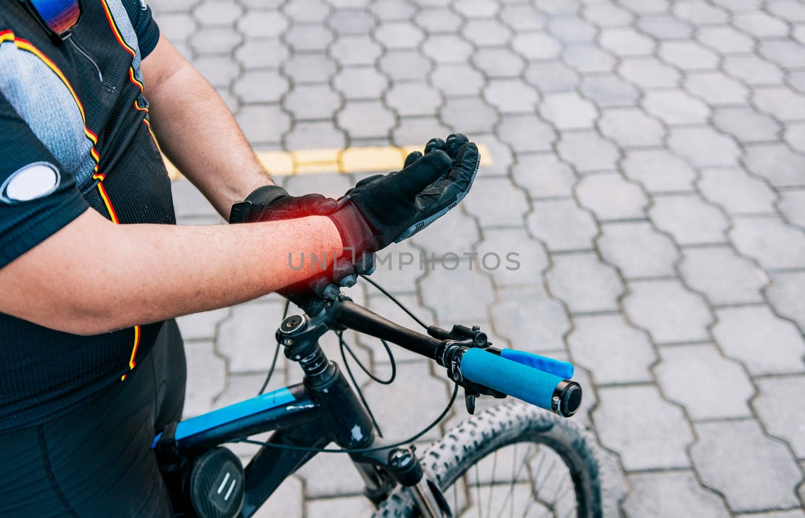 Cyclist man with hand pain outdoors. Close up of cyclist with arthritis outdoors by isaiphoto