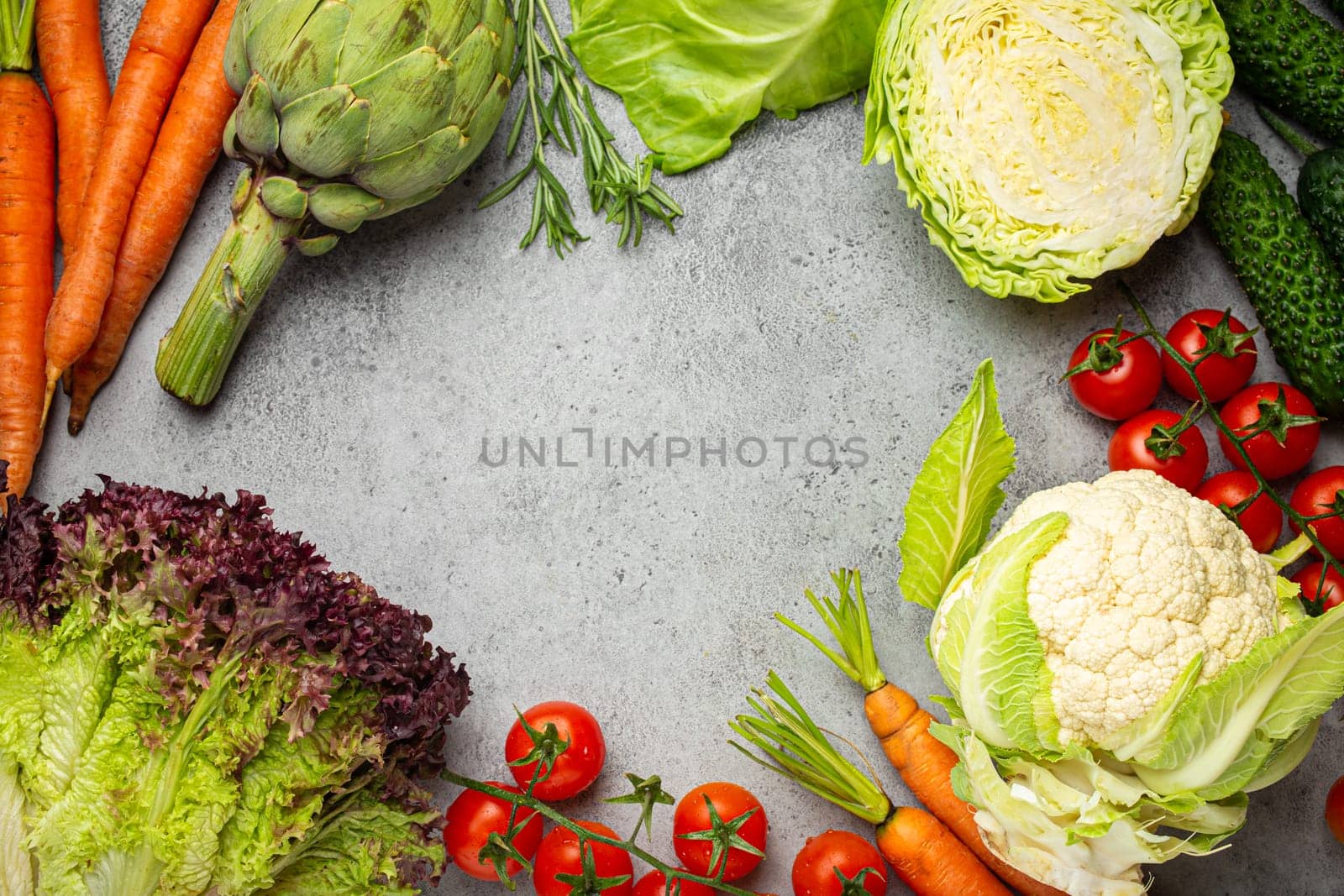 Fresh various organic vegetables on rustic grey stone table top view with copy space. Vegetarian food background and healthy vegetable ingredients with vitamins concept, diet and clean eating