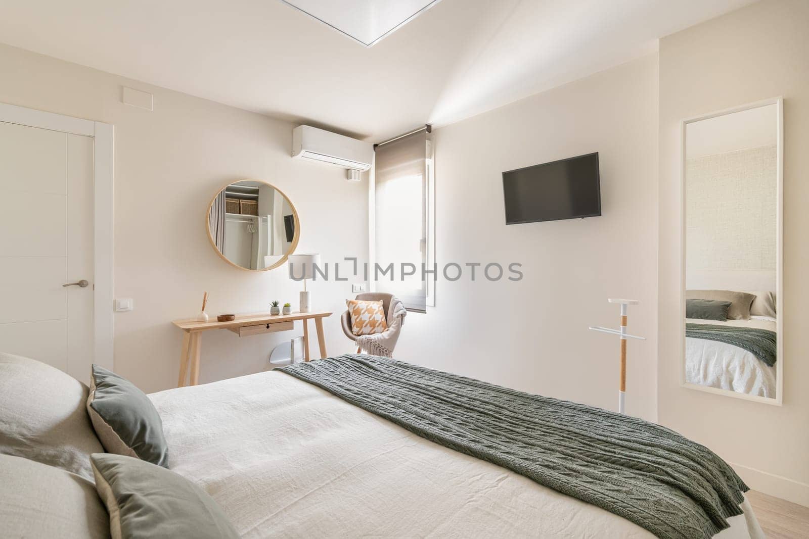 Spacious comfortable bedroom with a double bed, a cosmetic table and mirrors in an eco Scandinavian rustic interior. The concept of modern design in an apartment for a young family.