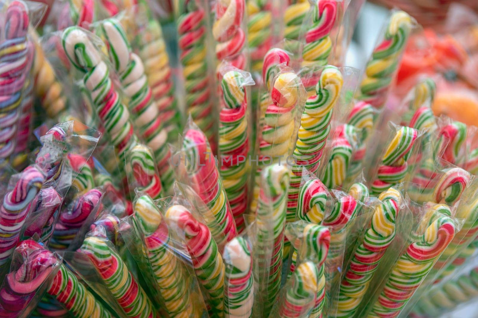 Sweets are harmful to health. Multi-colored sweets with a lot of sugar, in the form of sticks, are sold in a pastry shop. by SERSOL