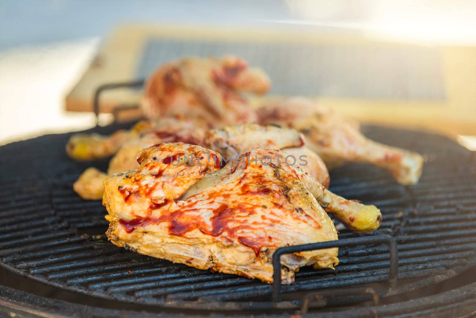 Barbecue outdoors. Grilling chicken on an industrial scale. Fresh chicken fried on the grill, marinated in red sauce. High quality photo