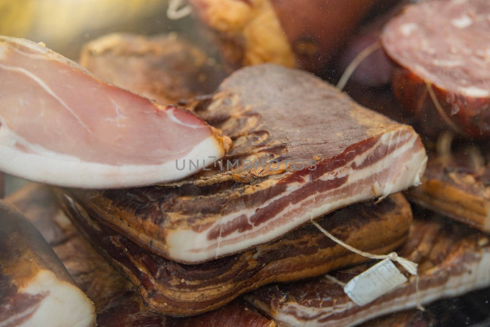 Smoked ham with cured bacon. Hams and bacon are ready for sale at the market. There are labels on them High quality photo