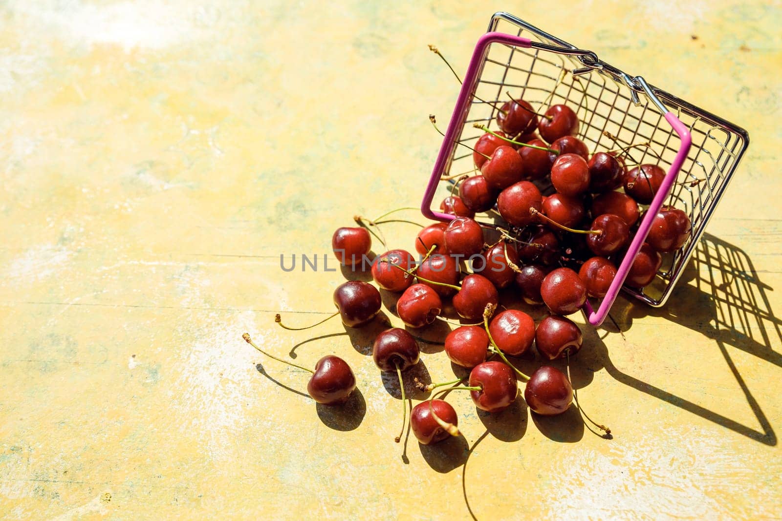 Fresh red fruit and berries - cherries, peaches and strawberries - in supermarket cart tray on black background. Copy space